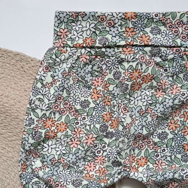 Ce pantalon évolutif est fait de coton, avec une bande évolutive à la taille. Il a un motif très printanier.