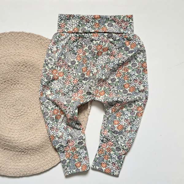 Ce pantalon évolutif est fait de coton, avec une bande évolutive à la taille. Il a un motif très printanier.