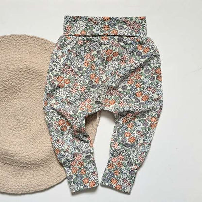 Ce pantalon évolutif est fait de coton, avec une bande évolutive à la taille. Il a un motif très printanier.