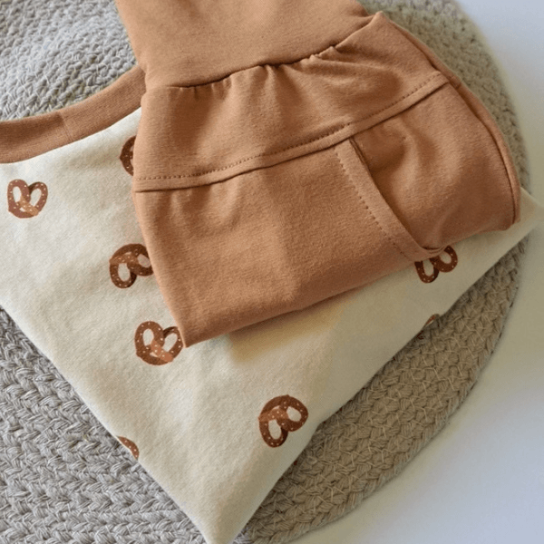 Pull Cache-Couche avec motif de bretzels et pantalon caramel