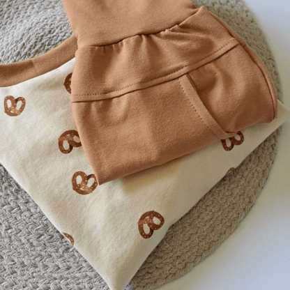 Pull Cache-Couche avec motif de bretzels et pantalon caramel