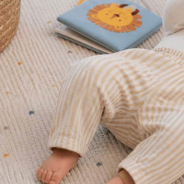 Bébé avec un petit pantalon jaune poussin